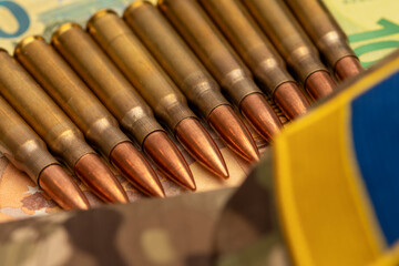 Naklejka premium Ammunition placed near Ukrainian camouflage uniform and euro banknotes.