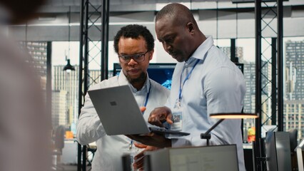 Team of technicians in office doing software development to launch new features. Startup coworkers writing computer programs, doing code testing and quality assurance, camera B