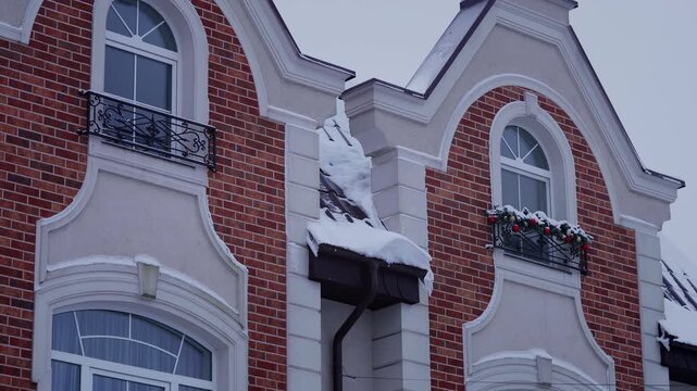 Brick House Facade With Christmas Balcony Decor And Snowy Roof