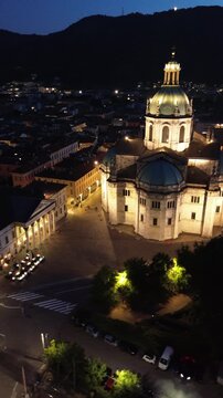 Spectacular vertical drone footage of Como Cathedral at night showcasing the illuminated dome and intricate statues with cinematic effects 3