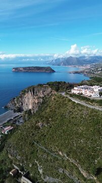 Spectacular vertical drone footage of Dino Island near Praia a Mare Calabria showcasing the coast and the contrast between the blue sea and green mountains