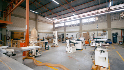 Spacious woodworking workshop with various industrial machinery and tools for processing wood and manufacturing furniture