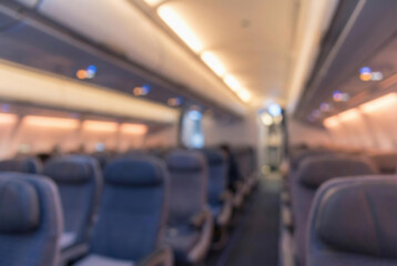 Fototapeta premium Blurry interior of an empty airplane cabin with rows of seats