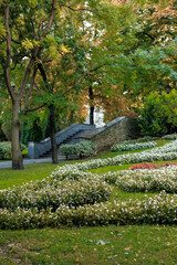 Lush garden landscape with flower beds and stone steps in autumn
