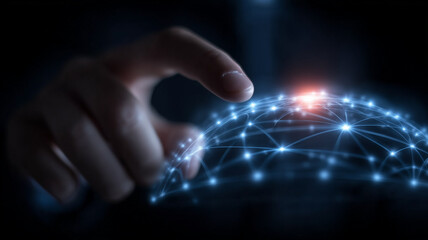 A human finger interacting with a glowing digital network sphere symbolizing global connectivity data exchange and intelligent communication.
