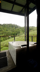 Relaxing private jacuzzi tub positioned on an outdoor balcony or terrace, offering panoramic views of the tropical jungle landscape