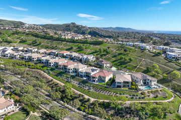 Aerial view over San Juan Capistrano, California, featuring the historic mission, library, sports courts, and an Amtrak train pulling into the downtown station. High quality 4k footage