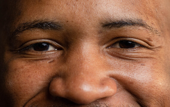 African American man gazing at camera, revealing skin texture, pores, and facial hair in studio