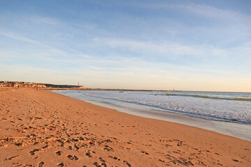 Obraz premium View of the calm ocean on a clay beach right before sunset
