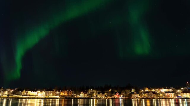 4K Timelapse of Green Aurora Borealis over Reykjavik Lake with City Houses, Iceland.