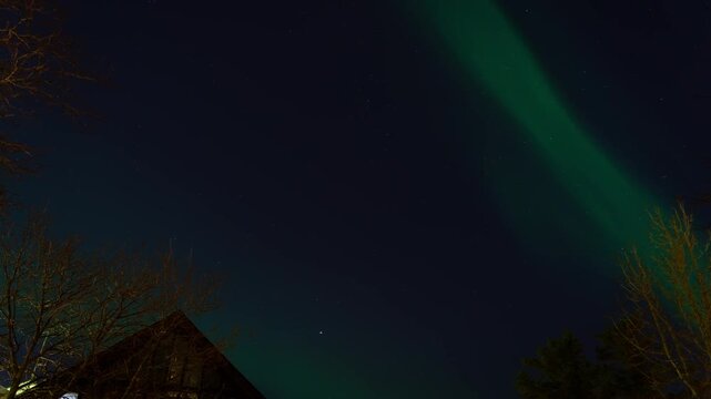 4K Night Timelapse of Northern Lights over Residential House Roof and Trees.
