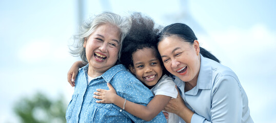 Three women are hugging each other in a park