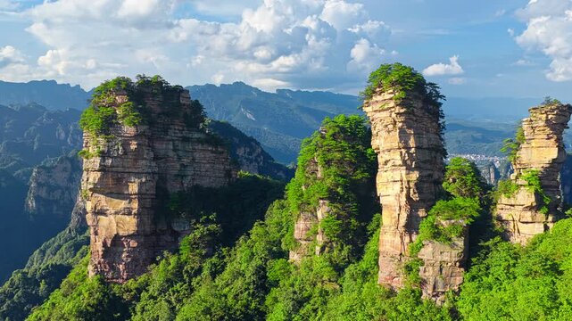 Aerial shot of majestic quartz sandstone pillars in Zhangjiajie National Forest Park, China under a clear blue sky.