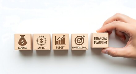 Wooden blocks with icons representing financial planning concepts like expense, saving, budget, and financial goals, with a hand placing the final block.