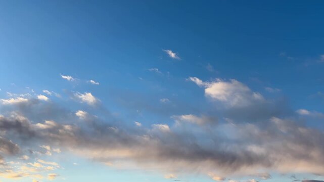 朝日に染まった雲が流れる青く澄んだ朝の空