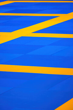 Bright blue and yellow floor design with geometric pattern in a modern space to practice martial arts