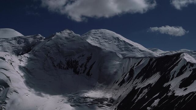 Incredible night running clouds 4K timelapse over Pamir mountains shooted from 5150m Yuhin peak with Krasin peak and Pik Dzerzhinskogo 6717m on Background. Beauty in Nature and extreme sport concept