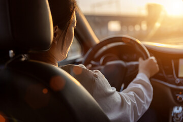 Female driver driving a car from the rear seat perspective