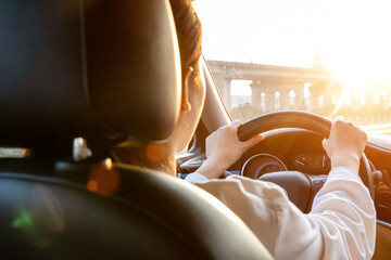 Female driver driving a car from the rear seat perspective