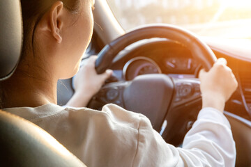 Female driver driving a car from the rear seat perspective