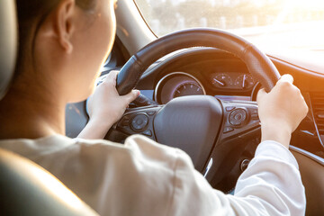 Female driver driving a car from the rear seat perspective