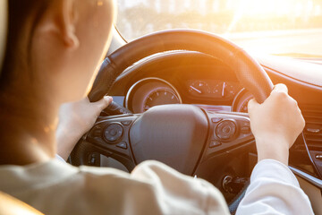 Female driver driving a car from the rear seat perspective