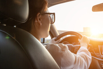 Female driver driving a car from the rear seat perspective