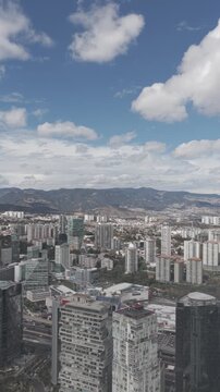 Aerial drone panning over Santa Fe skyline with skyscrapers, residential towers and mountains in M&eacute;xico City. Vertical video