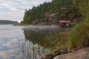 Wooden bathhouse on the shore of Lake Ladoga near the village of Lumivaara on a foggy autumn morning, Ladoga Skerries, Lahdenpohya, Republic of Karelia, Russia