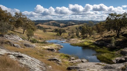 Naklejka premium Tranquil Seasonal Landscape with Calm Water Reflection and Rolling Hills