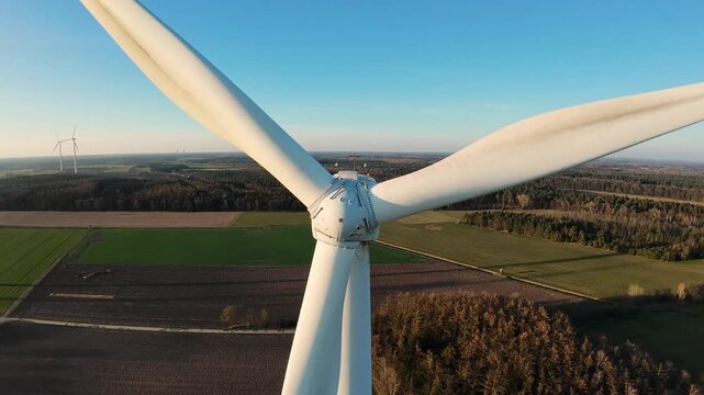 Dynamic Close Sweep Of Turbine Blades Passing Overhead With Dramatic Speed, Drone Pilot Captures Proximity And Kinetic Motion, Rural Patchwork Fields And Clear Sky Frame The Scene