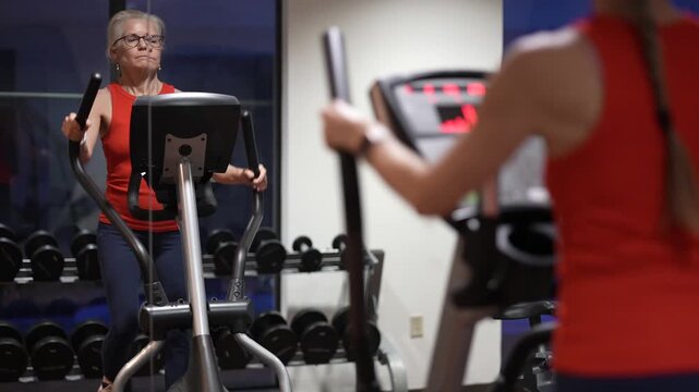 A woman works out at the gym using an elliptical machine to improve her fitness and strength during a daily exercise routine.