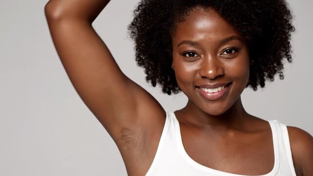 Beautiful Black woman with curly hair smiles, arm raised