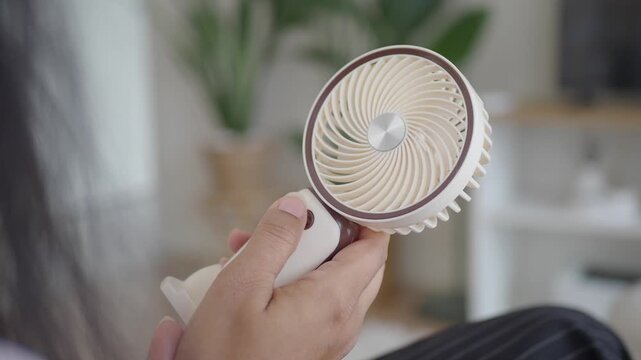 Handheld fan provides cool air during hot weather