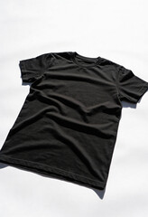 A black t-shirt lies crumpled on a white surface