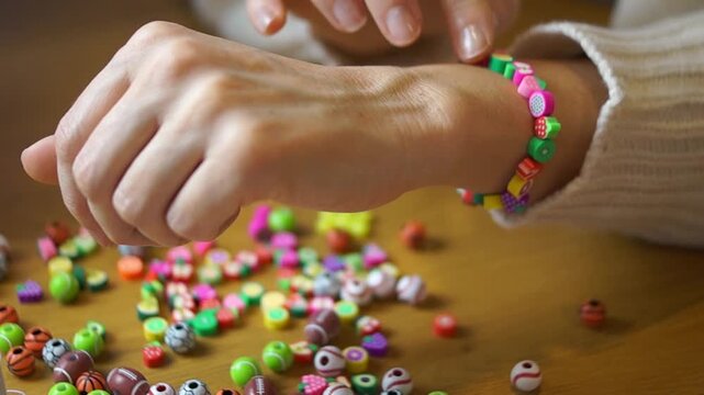 Woman showing finished colorful bead bracelet in her hands