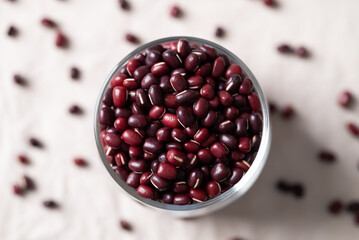 Top view of Azuki beans, Adzuki bean or red mung beans in glass on white fabric background, Food ingredients in many Chinese dishes and filling in Japanese sweet