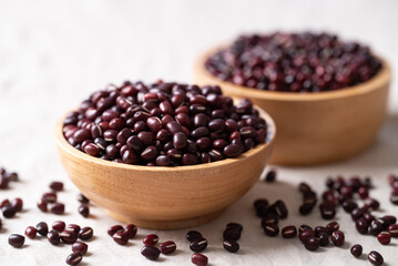 Azuki beans, Adzuki bean or red mung beans in wooden bowl on white fabric background, Food ingredients in many Chinese dishes and filling in Japanese sweet