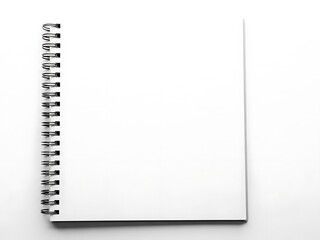 A top view of a blank spiral-bound notebook on a white surface with subtle shadow details