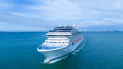 a large luxury cruise ship sailing in the deep blue ocean. White passenger vessel featuring swimming pools on the top deck. Summer vacation and international tourism concept.