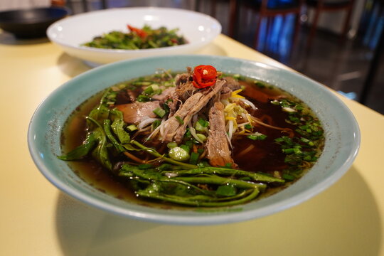 Traditional Thai Duck Noodle Soup (Kuay Tiao Ped) with Shredded Meat, Bean Sprouts, and Water Spinach
