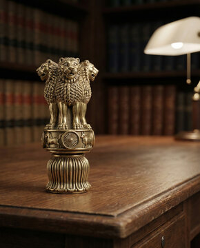 Golden National Emblem of India on wooden desk in law library office