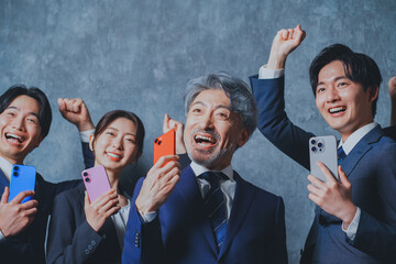 スマートフォンを手に持って喜ぶビジネスマン