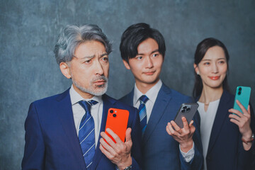 スマートフォンを手に持って悩むビジネスマン