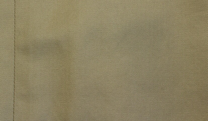 Beige fabric texture. Beige fabric used for trench coat background. Close-up of beige cloth with vertical seam.
