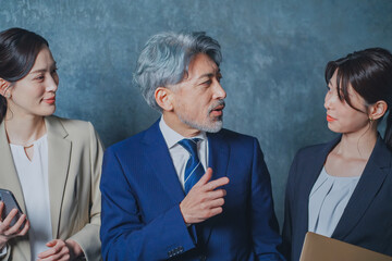 秘書に指示を出すエグゼクティブな50代ビジネスマン