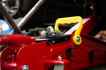 Red car jack supporting a vehicle during a tire change or repair