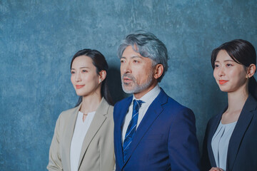 エグゼクティブな50代ビジネスマンと美人秘書チーム