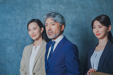 エグゼクティブな50代ビジネスマンと美人秘書チーム