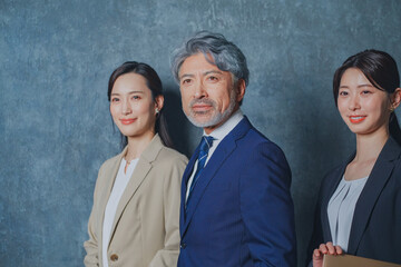 エグゼクティブな50代ビジネスマンと美人秘書チーム